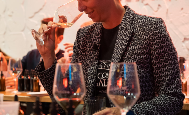 Mujer oliendo una copa de vino en el taller de ensamblaje de vino, evento del Club Winelovers, en Winelovers Salamanca